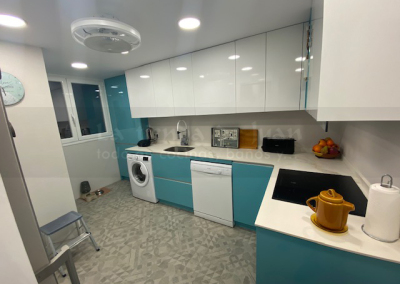 Cocina DiGiovanni, Reforma, Zaragoza, cocina, Mueble a medida, cocina moderna, cocina blanca, blanco y marmol, taburete alto, barra, mesa alta, Porcelanosa, tirador oculto, amueblamiento, Silestone, Dekton, Consentino, encimera crema, campana oculta, barra desayuno, Balay, Bosch, cemento, reloj cocina, mueble auxiliar, electrodomesticos negros,, horno cristal negro, microondas cristal negro, frigorifico acero, cocina, suelo crema, decorativo, cocina alargada, baldosa blanca, mueble microondas, taburete rojo, cocina azul, turquesa, mueble caldera, decorativo