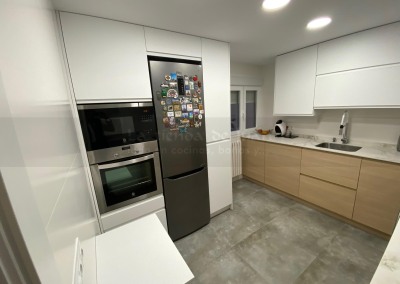 Cocina DiGiovanni, Reforma, Zaragoza, cocina, Mueble a medida, cocina moderna, cocina blanca, blanco y marmol, taburete alto, barra, mesa alta, Porcelanosa, tirador oculto, amueblamiento, Silestone, Dekton, Consentino, encimera crema, campana oculta, barra desayuno, Balay, Bosch, cemento, reloj cocina, mueble auxiliar, electrodomesticos negros,, horno cristal negro, microondas cristal negro, frigorifico acero, cocina, suelo crema, decorativo, cocina alargada, baldosa blanca, mueble microondas, taburete rojo, cocina azul, turquesa, mueble caldera, decorativo, encimera granito negro, tira led, luz led, mueble blanco, electrodomésticos cristal blanco, encimera marmol blanco, frontal blanco y madera, papel pintado, mueble madera y blanco, campana cristal