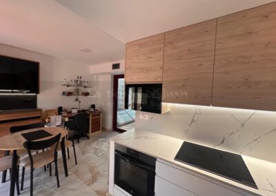 Cocina DiGiovanni, Reforma, Zaragoza, cocina, Mueble a medida, cocina moderna, cocina blanca y negra, taburete madera, Porcelanosa, Saloni, tirador oculto negro, amueblamiento, Silestone, Dekton, Consentino, encimera negra, campana decorativa cristal negro, Balay, Bosch, reloj cocina, mueble auxiliar, electrodomesticos negros, horno cristal negro, microondas cristal negro, frigorifico acero, cocina, suelo gris, decorativo, cocina alargada, baldosa blanca, mueble microondas, decorativo, tira led, luz led, mueble blanco, frontal, mueble madera y blanco, mueble blanco, electrodomesticos acero, mueble blanco, campana decorativa negra, columna horno microondas, frigorífico cajones, pared pizarra, mueble azul mate