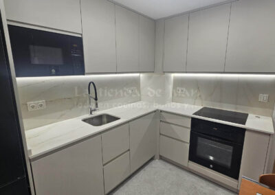 Cocina DiGiovanni, Reforma, Zaragoza, cocina, Mueble a medida, cocina moderna, cocina blanca y negra, taburete madera, Porcelanosa, Saloni, tirador oculto negro, amueblamiento, Silestone, Dekton, Consentino, encimera negra, campana decorativa cristal negro, Balay, Bosch, reloj cocina, mueble auxiliar, electrodomesticos negros, horno cristal negro, microondas cristal negro, frigorifico acero, cocina, suelo gris, decorativo, cocina alargada, baldosa blanca, mueble microondas, decorativo, tira led, luz led, mueble blanco, frontal, mueble madera y blanco, mueble blanco, electrodomesticos acero, mueble blanco, campana decorativa negra, columna horno microondas, frigorífico cajones, pared pizarra, mueble azul mate